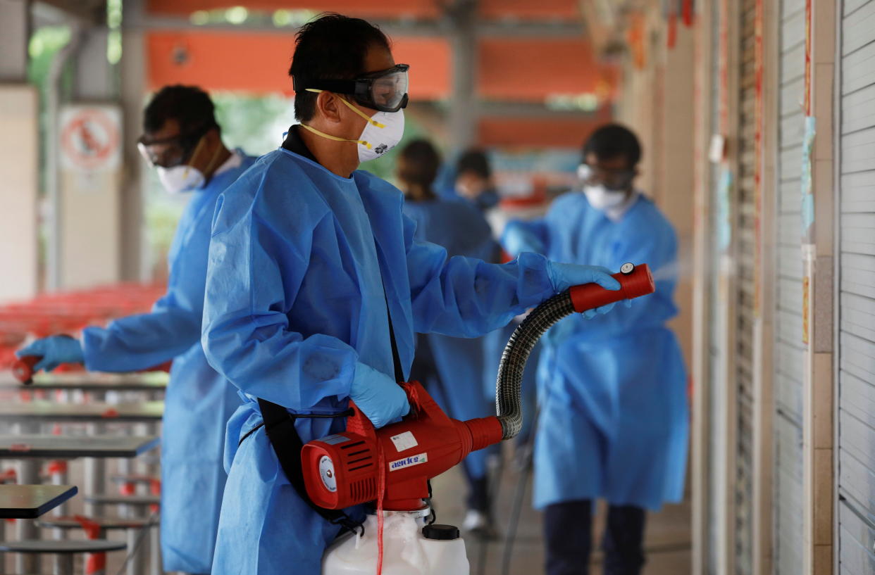 Cleaners disinfect a food center that was closed down after a hawker tested positive for the coronavirus disease (COVID-19), in Singapore, June 16, 2021. REUTERS/Edgar Su