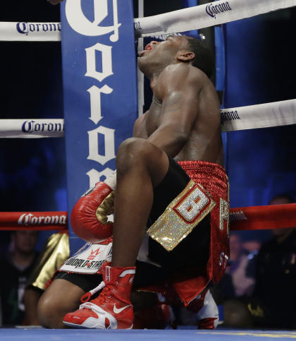 Adrien Broner falls after he was head butted by Marcos Maidana during a title bout in 2013. (AP)