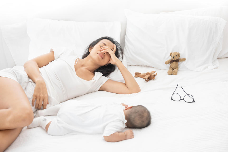 Tired Exhausted Mother Sleeping Sleep With Baby On White Bed. 