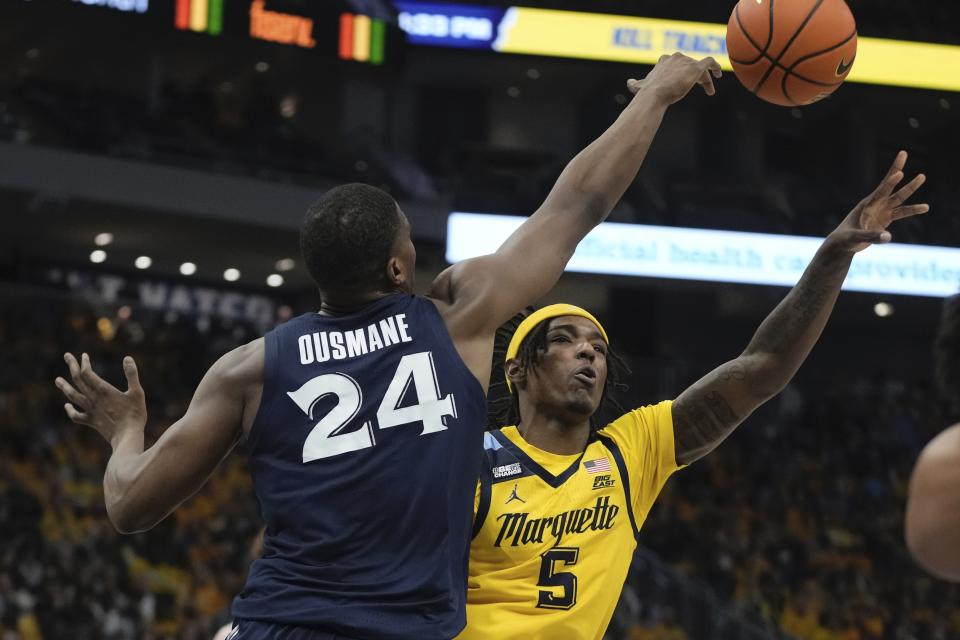 Marquette's Tre Norman shoots past Xavier's Abou Ousmane during the first half of an NCAA college basketball game Sunday, Feb. 25, 2024, in Milwaukee. (AP Photo/Morry Gash)