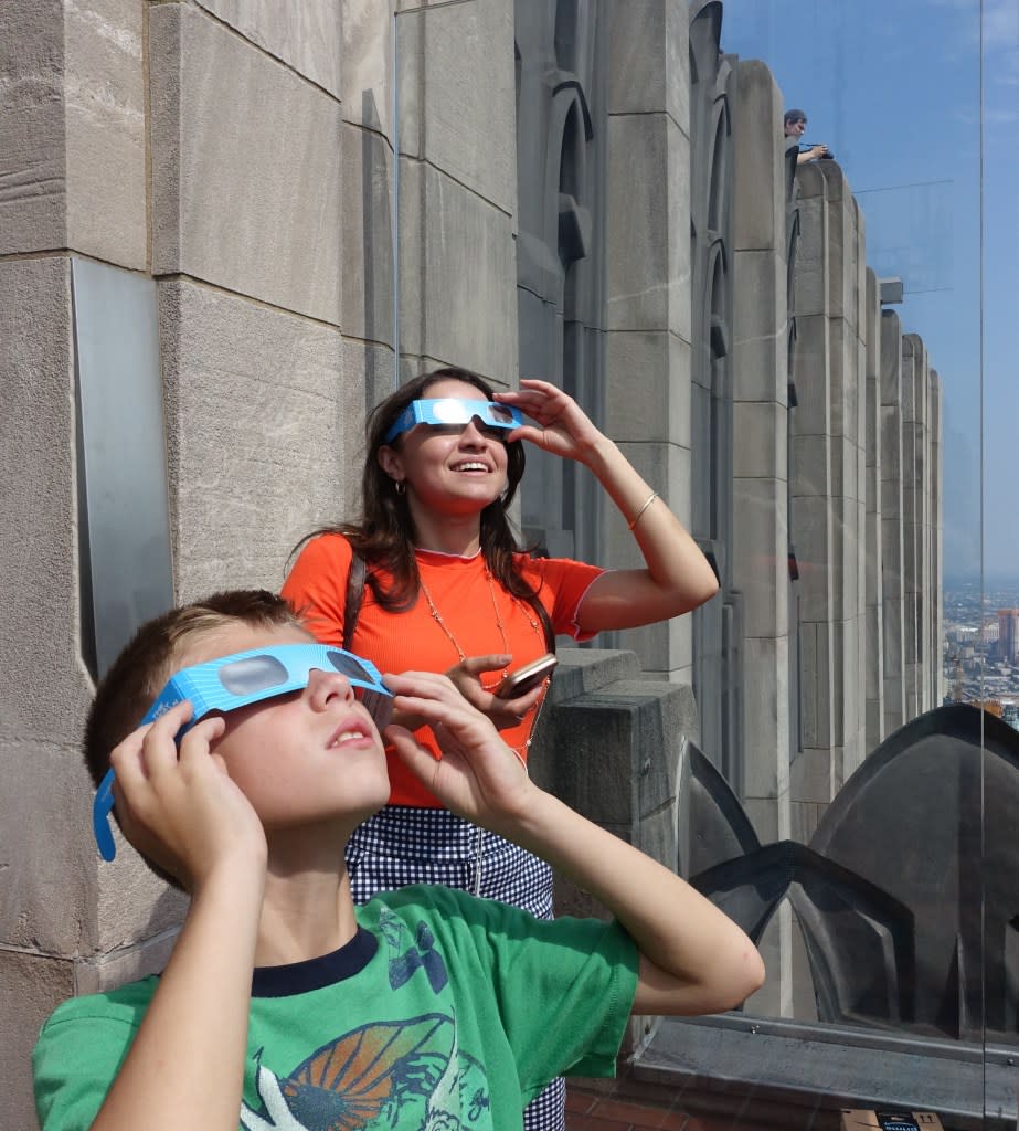 Emilio Sanducci, 8, of Dyker Heights, and Christina Garcia, of Forest Hills, view a solar eclipse in this view from Top of the Rock on Aug. 21, 2017, in New York. N.Y. Post: CHAD RACHMAN