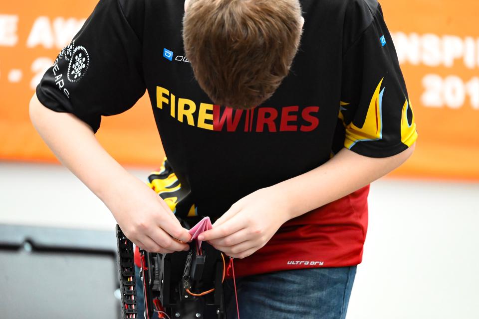 FireWires team member Zachary Thain inserts a paper airplane into the robot, prior to its launch to score more points during practice at GEARS in Osceola on March 17, 2024.