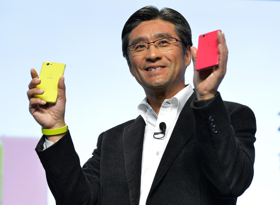 Kunimasa Suzuki, executive vice president, Sony Corporation and president and chief executive officer of Sony Mobile Communications, unveils the new Sony EXPERIA Z1 Compact in lime and pink colors during the Sony news conference at the International Consumer Electronics Show Monday, Jan. 6, 2014, in Las Vegas. The smaller phone has the same features as the ZPERIA Z1(AP Photo/Jack Dempsey)