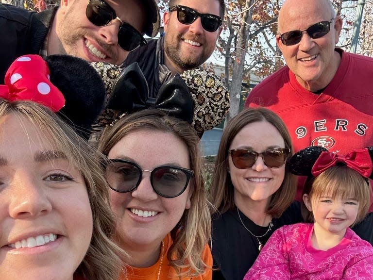 ali and her family posing for a selfie together at disneyland