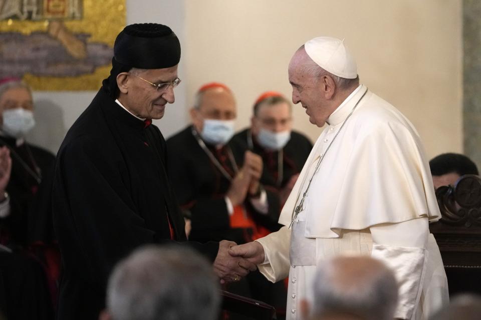 Pope Francis, right, shakes hands with Cardinal Bechara Boutros Rai during a ceremony at the Maronite Cathedral of Our Lady of Graces in Nicosia, Cyprus, Thursday, Dec. 2, 2021. Pope Francis' trip to Cyprus and Greece is drawing new attention to the plight of migrants on Europe's borders and the disconnect between Francis' Gospel-driven call for countries to welcome and integrate them and front-line governments that are increasingly unwilling or unable to let them in. (AP Photo/Alessandra Tarantino)