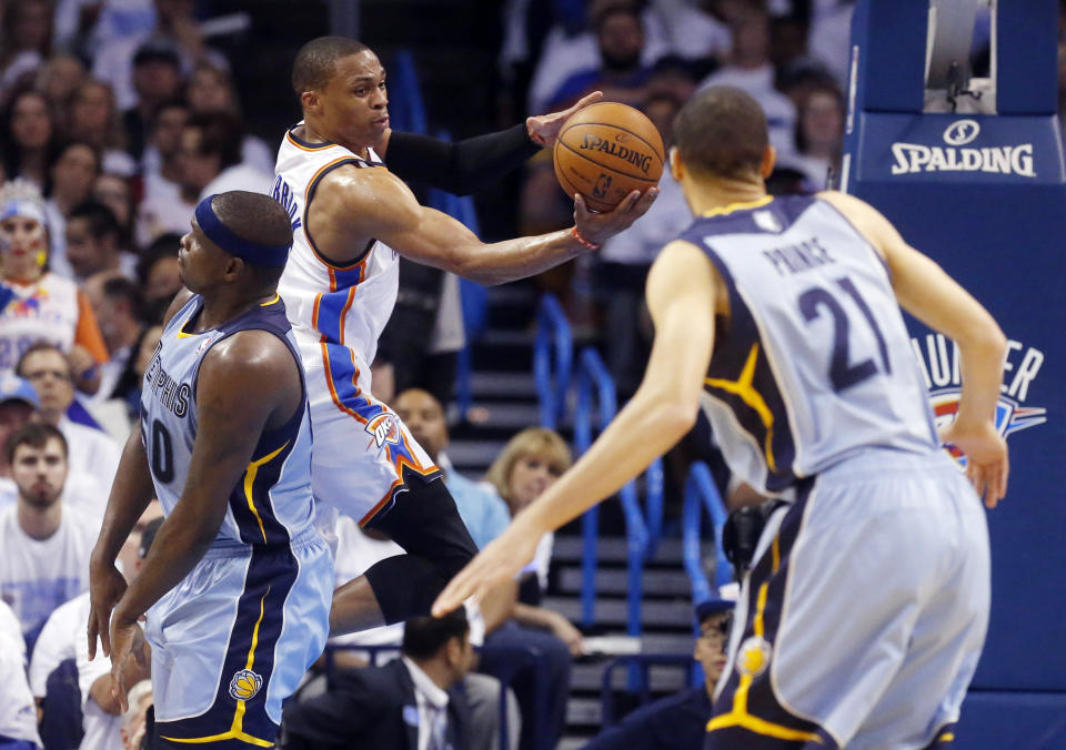 Oklahoma City Thunder guard Russell Westbrook, second from left, passes between Memphis Grizzlies forward Zach Randolph (50) and forward Tayshaun Prince (21) in the second quarter of Game 5 of an opening-round NBA basketball playoff series in Oklahoma City, Tuesday, April 29, 2014. (AP Photo)