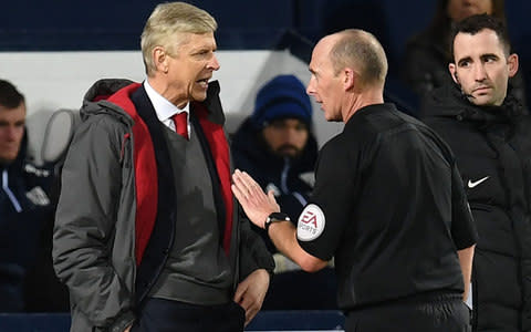 Arsenal's French manager Arsene Wenger (L) has words with English referee Mike Dean during the English Premier League football match between West Bromwich Albion and Arsenal at The Hawthorns stadium in West Bromwich, central England, on December 31, 2017 - Credit: AFP