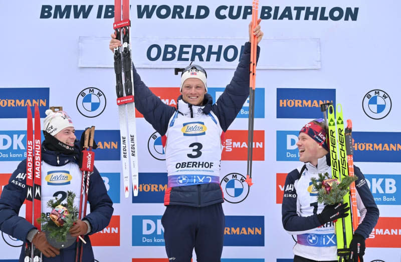 (L-R) Norway's second-placed Sturla Holm Laegreid, Norway's first-placed Endre Stroemsheim, and  Norway's third-placed Johannes Dale-Skjevdal celebrate on the podium after the men's pursuit of 12.5 km of the Biathlon World Cup in the Lotto Thüringen Arena at Rennsteig. Martin Schutt/dpa