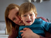 Katja Heimann comforts her son Oskar, who suffers from a very rare gene defect, in Eisemroth, central Germany, Thursday, March 25, 2021. One year into the coronavirus pandemic, Katja Heimann is still trying to keep her spirits up - despite several lockdowns and months of teaching seven of her children in home schooling. (AP Photo/Michael Probst)