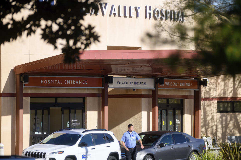 A security guard leaves NorthBay VacaValley Hospital, where a woman diagnosed with coronavirus previously sought treatment, on Thursday, Feb. 27, 2020, in Vacaville, Calif. Public health officials are retracing the steps of the woman, believed to be the first person in the U.S. to contract the highly contagious coronavirus without traveling abroad or coming in close contact with an international traveller. (AP Photo/Noah Berger)