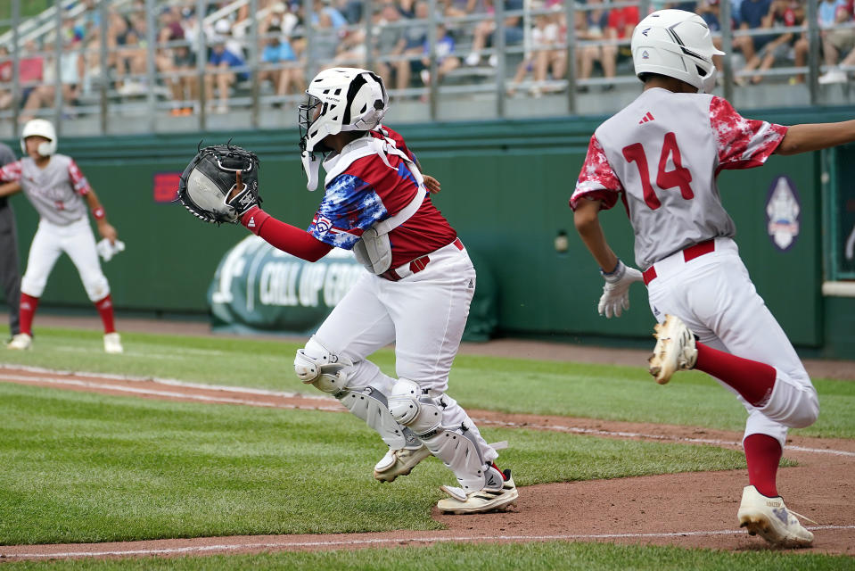 Cuba's Didier Castillo (15) goes after the late throw as Japan's Hinata Uchigaki (14) scores during the first inning of a baseball game at the Little League World Series tournament in South Williamsport, Pa., Wednesday, Aug. 16, 2023. (AP Photo/Tom E. Puskar)