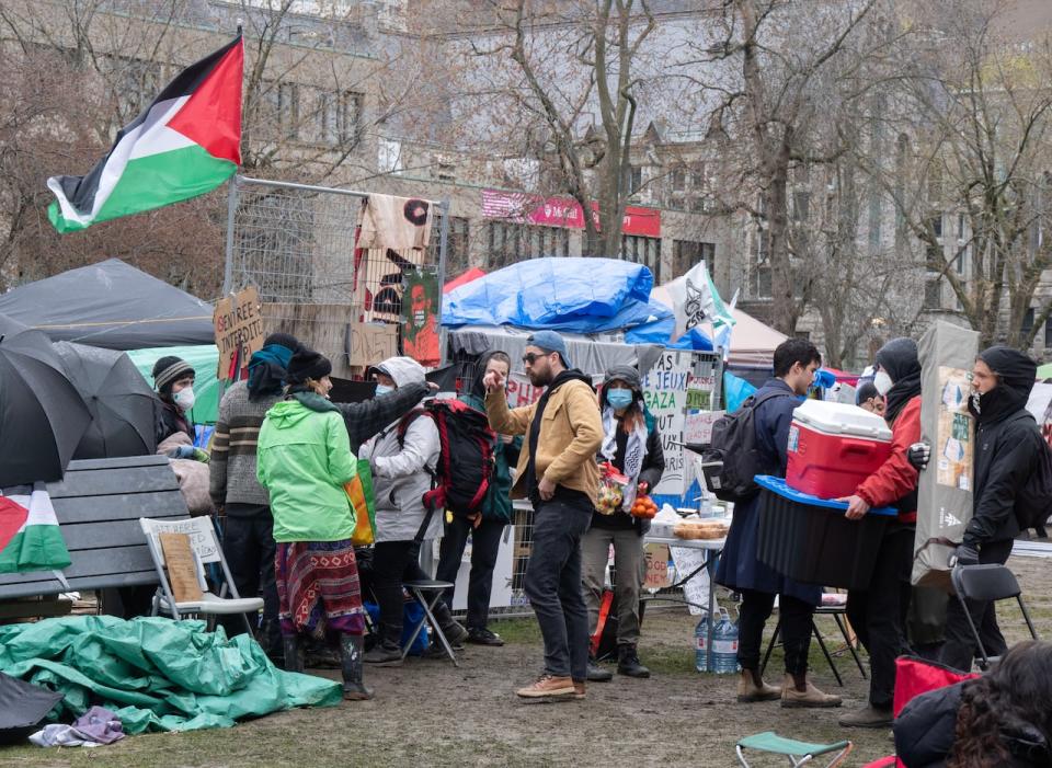 Pro-Palestinian activists bring in supplies at their encampment on the McGill University campus Tuesday, April 30, 2024  in Montreal.