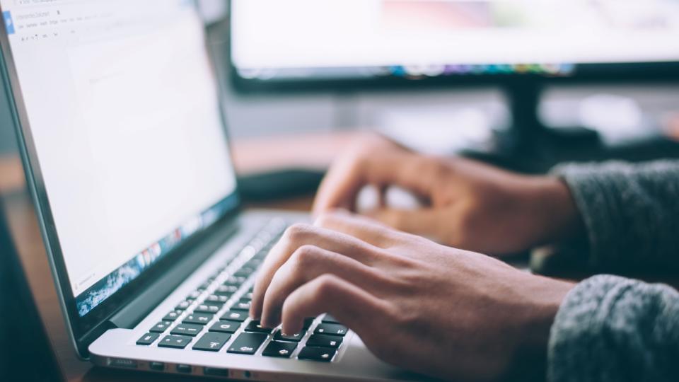 Person writing on computer.