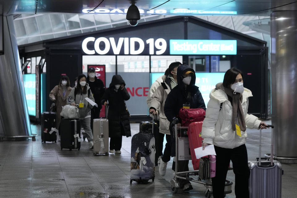 Passengers arriving from China pass by a COVID-19 testing center at the Incheon International Airport in Incheon, South Korea on Jan. 14, 2023. A hoped-for boom in Chinese tourism in Asia over next week’s Lunar New Year holidays looks set to be more of a blip as most travelers opt to stay inside China if they go anywhere. (AP Photo/Ahn Young-joon)