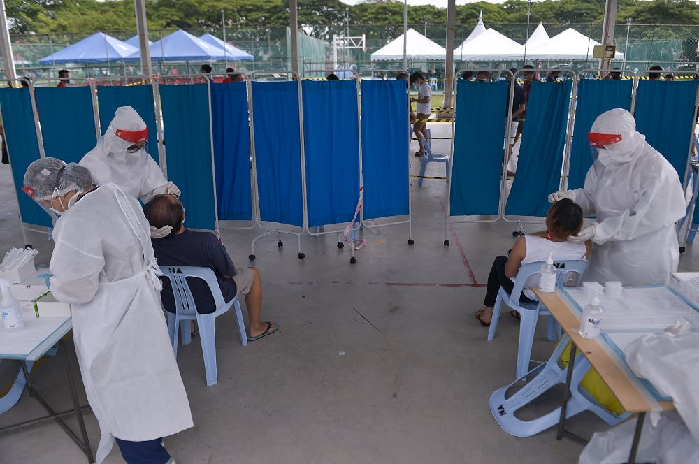 Healthcare workers collect swab samples to test for Covid-19 at the Selcare Clinic in Shah Alam June 24, 2021. — Picture by Miera Zulyana