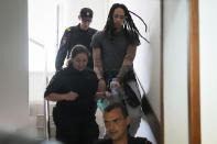 WNBA star and two-time Olympic gold medalist Brittney Griner is escorted to a courtroom for a hearing, in Khimki just outside Moscow, Russia, Monday, June 27, 2022. More than four months after she was arrested at a Moscow airport for cannabis possession, American basketball star Brittney Griner is to appear in court Monday for a preliminary hearing ahead of her trial. (AP Photo/Alexander Zemlianichenko)