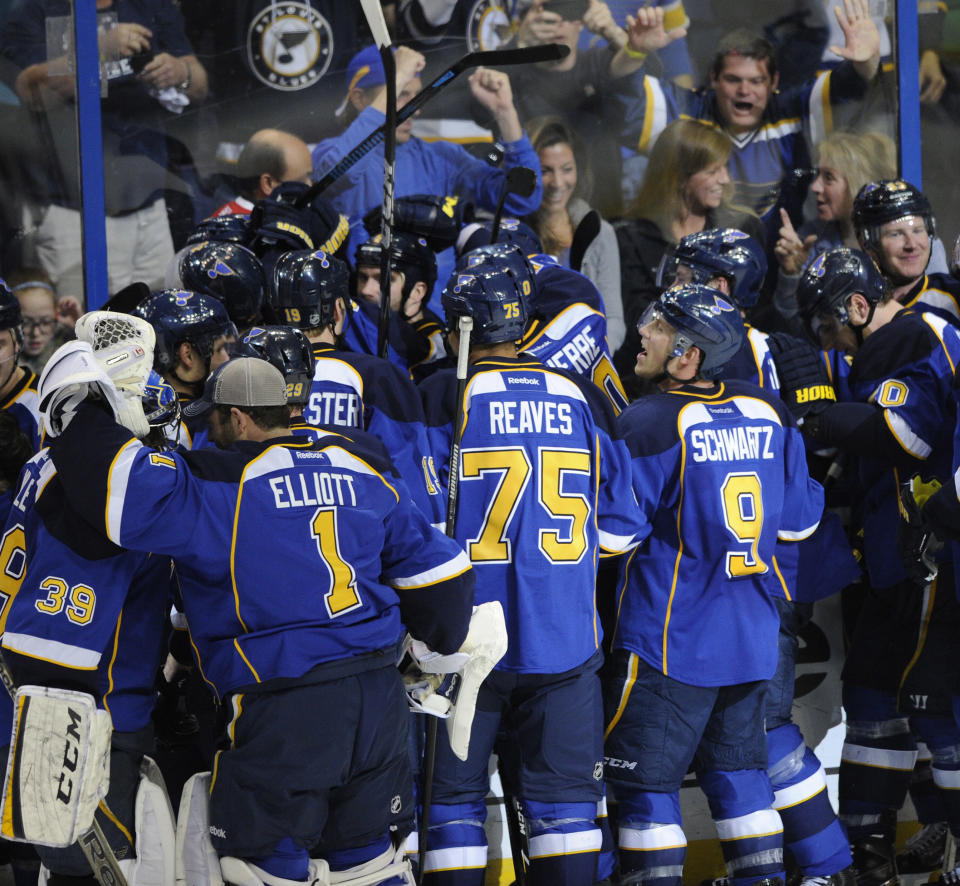 St. Louis Blues surround teammate Barret Jackman, center, after his game-winning goal against the Chicago Blackhawks during overtime in Game 2 of a first-round NHL hockey playoff series, Saturday, April 19, 2014, in St. Louis. (AP Photo/Bill Boyce)