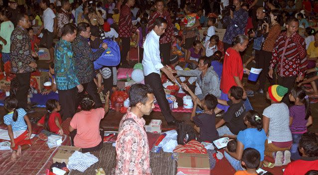 Indonesian President Joko Widodo, center, greets villagers at an evacuees' camp in Klungkung. Photo: AAP