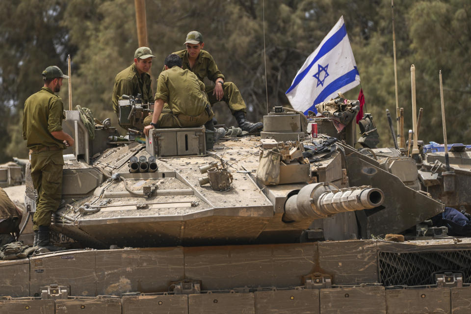 Israeli soldiers work on a tank near the Israeli-Gaza border, in southern Israel, Wednesday, May 29, 2024. (AP Photo/Tsafrir Abayov)