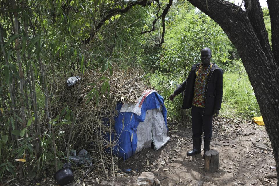 Patrick Komakech shows a makeshift accommodation for the charcoal burners in Gulu, Uganda, May 27 2023. Uganda's population explosion has heightened the need for cheap plant-based energy sources, especially charcoal. (AP Photo/Hajarah Nalwadda)