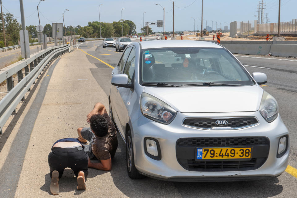 Israelis take cover during rocket fire from the Gaza Strip near the city of Herzliya on May 26, 2024, amid the ongoing conflict between Israel and the Palestinian militant group Hamas. (Photo by JACK GUEZ / AFP) (Photo by JACK GUEZ/AFP via Getty Images)