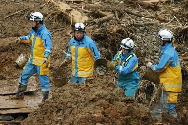 Police officers carry earth and sand by buckets as they search for the missing in Tsunagi town, Kumamoto prefecture, southern Japan (Kyodo News/AP)