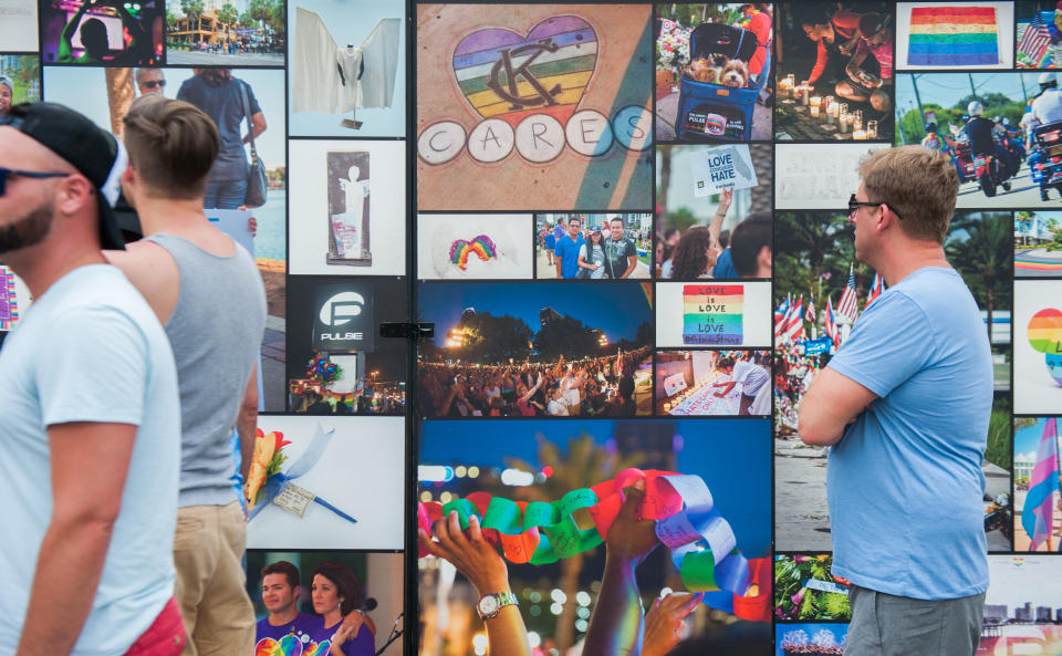 Visitors look at a wall of photos at the new interim Pulse nightclub memorial in Orlando, Florida on June 4 2018.