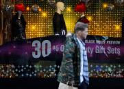 A man walks past a sign advertising Black Friday offers at a House of Fraser store in Manchester, Britain