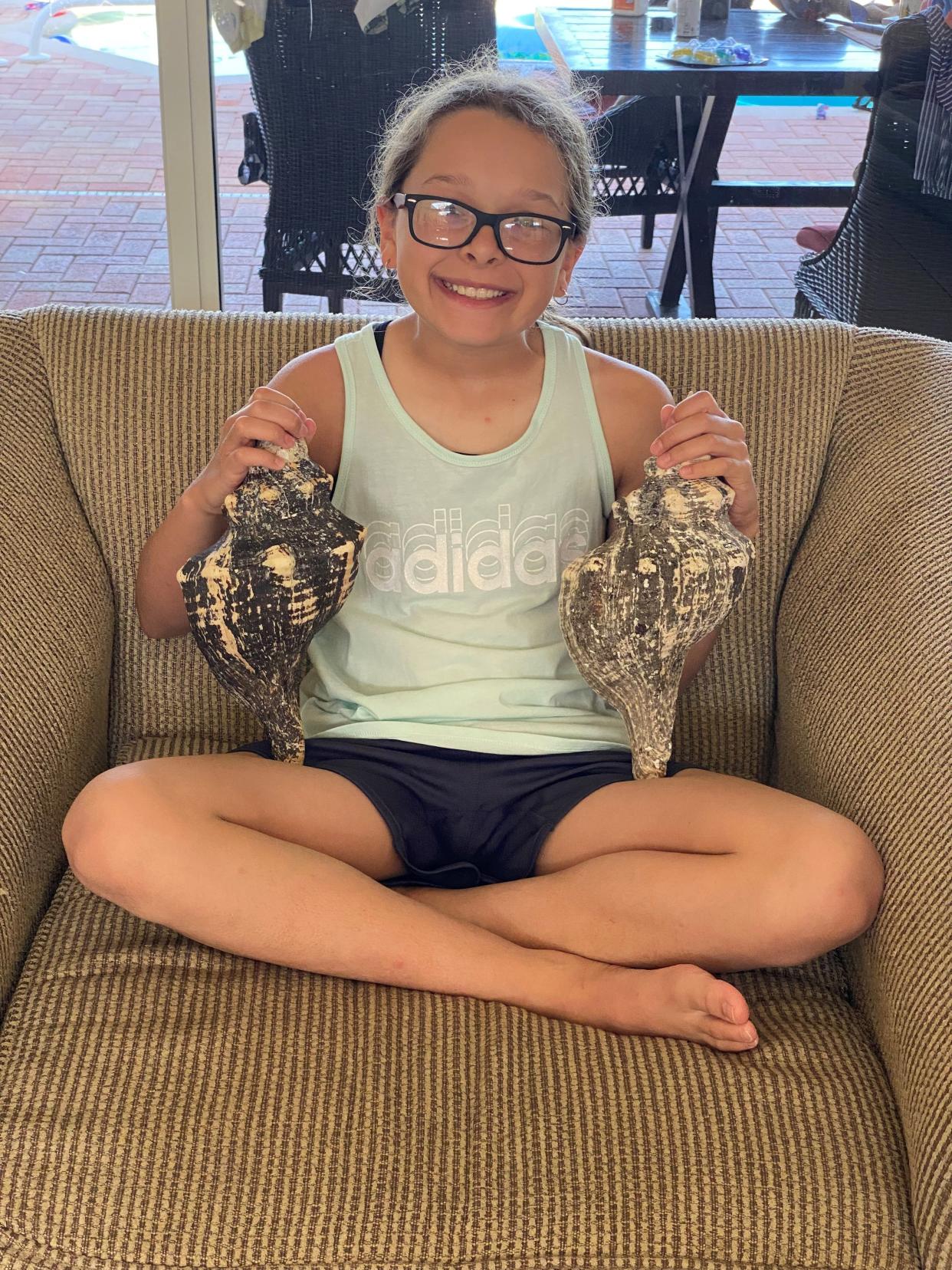 Jessica Reyna's daughter, Delaney Kain, holds the two shells the family found on a recent visit to Sanibel Island.