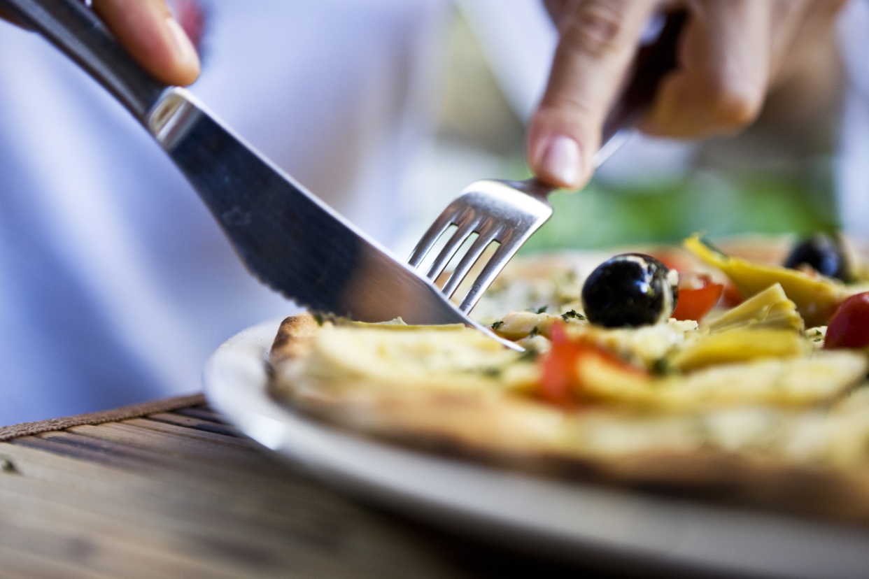 Closeup of Fork and Knife in a Pizza, Taking a Piece, Selective Focus