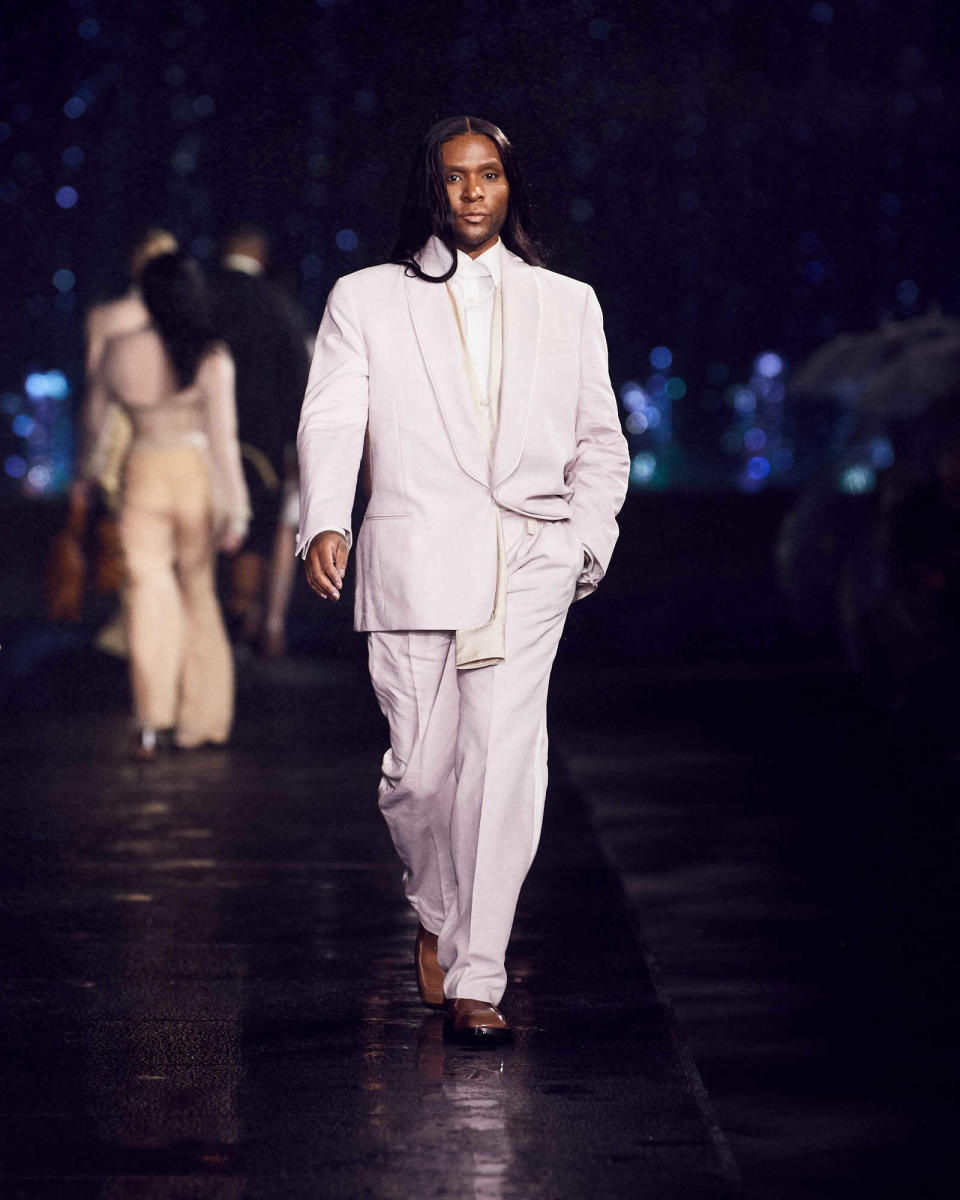 Law Roach walks the Boss show in tan suiting.