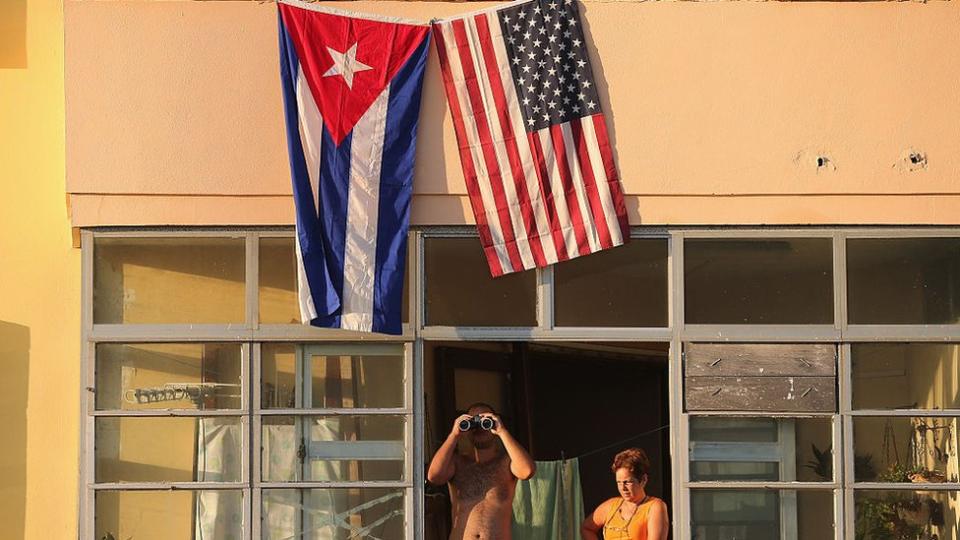 Ciudadanos cubanos observan desde una ventana la ceremonia de apertura de la embajada de EE.UU. en La Habana.