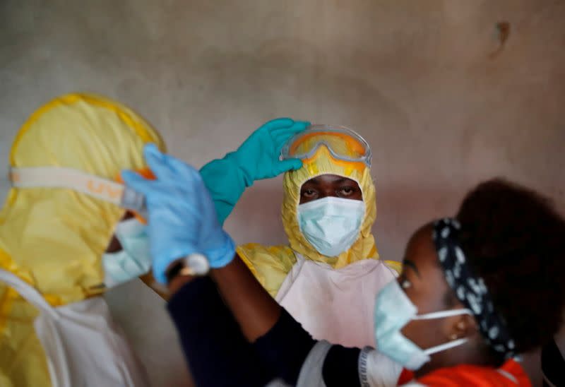 FILE PHOTO: Healthcare workers adjust gear during a funeral of a person who is suspected of dying of Ebola in Beni,