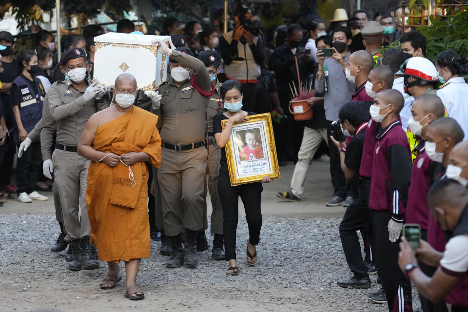 Police carry a coffin containing a victim in the day care center attack for cremation at Wat Rat Samakee temple in Uthai Sawan, northeastern Thailand, Tuesday, Oct. 11, 2022. A former police officer burst into a day care center in northeastern Thailand on Thursday, killing dozens of preschoolers and teachers before shooting more people as he fled. (AP Photo/Sakchai Lalit)