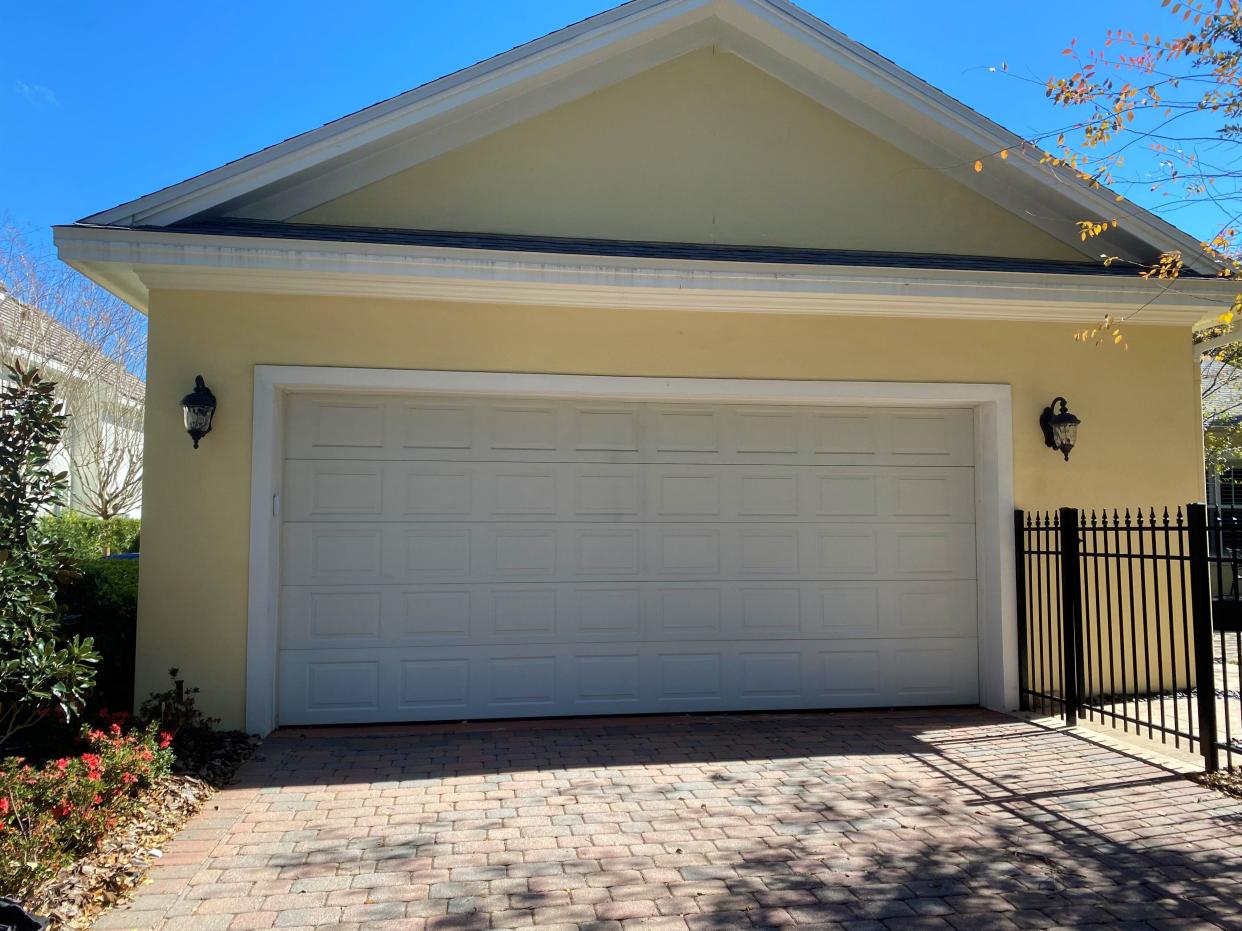 Before: Under-scaled carriage lamps look out of proportion on this home’s exterior.