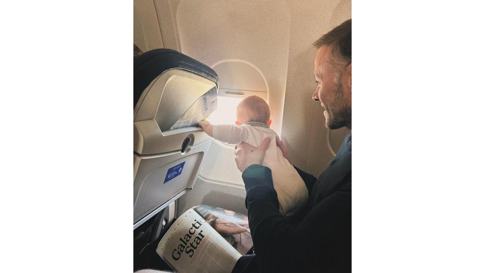 father holding baby daughter in plane