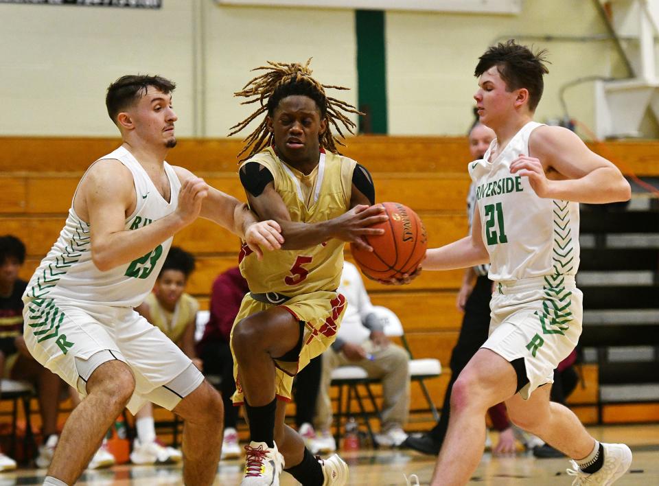 Riverside's Sam Hughes (23) and Drake Fox (21) guard New Brighton's Marquis White during Friday night's game at Riverside High School.