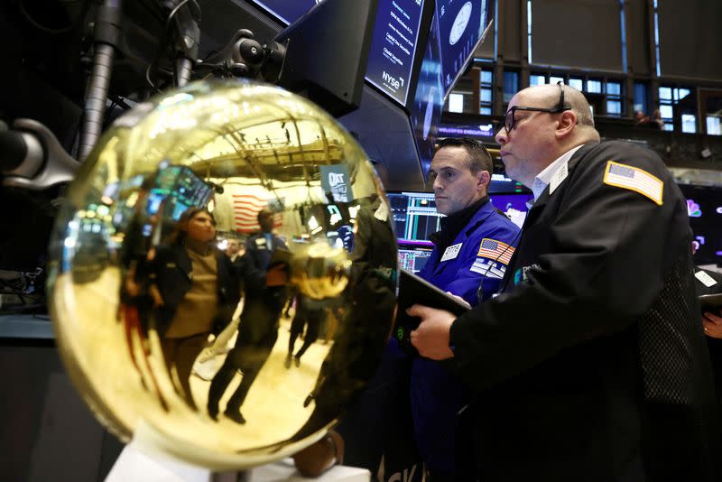 FILE PHOTO: Traders work on the trading floor at the New York Stock Exchange (NYSE) in New York City