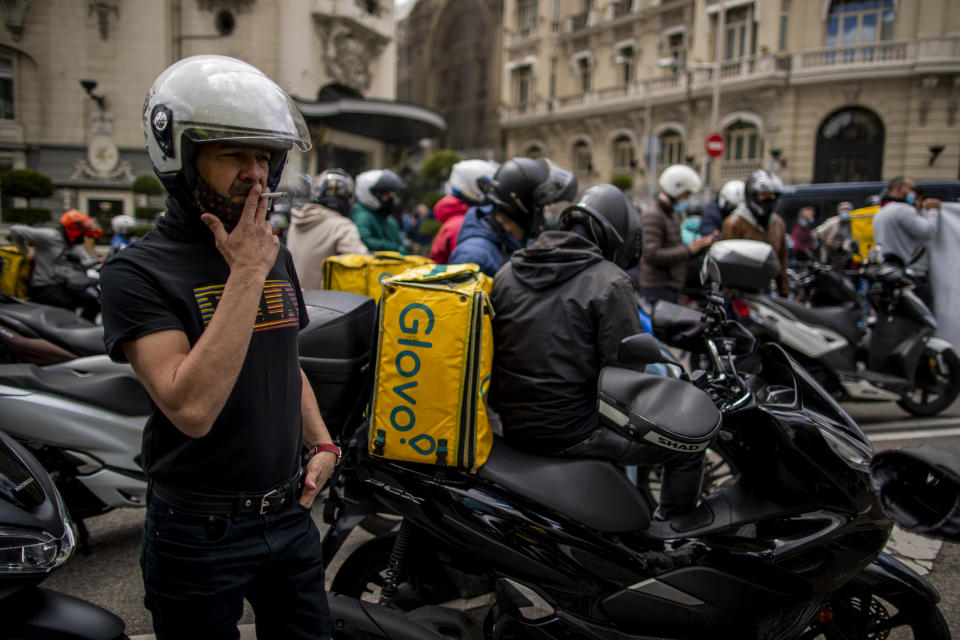 Delivery workers gather during a protest in front of the Spanish Parliament in Madrid, Spain, Tuesday, May 11, 2021. Spain has approved a pioneering law that gives delivery platforms a mid-August deadline to hire the workers currently freelancing for them and that requires transparency of artificial intelligence to manage workforces. (AP Photo/Manu Fernandez)