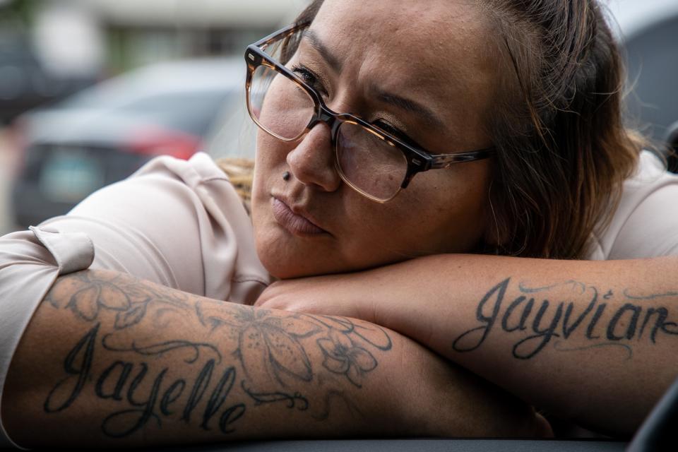 Fort Berthold reservation resident Rachelle Baker leans into the window of MHA Drug Enforcement special agent Dawn White's cruiser. Baker was a school teacher when White, her aunt, arrested her in 2013 on charges related to heroin. The names of Baker's two children on her forearms help to cover the scars from past intravenous needle use and give her inspiration to stay sober. Today, Baker works to educate locals on addiction.
