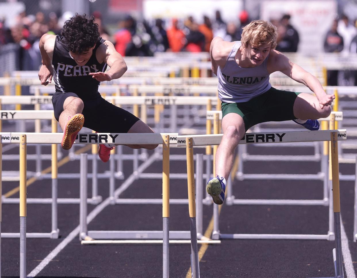 Perry's Kyson Walker (left) competes with GlenOak's Braedon Paolini in the boys 110-meter hurdles at Saturday's Stark County Track and Field Championships.