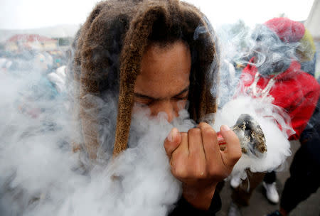 FILE PHOTO: A man smokes marijuana, known locally as dagga, during a march calling for the legalisation of cannabis in Cape Town, South Africa, May 6, 2017. REUTERS/Mike Hutchings/File Photo