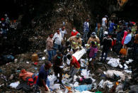 Rescue workers carry the body of a victim recovered out from a pile of garbage following a landslide when a mound of trash collapsed on an informal settlement at the Koshe garbage dump in Ethiopia's capital Addis Ababa, March 13, 2017. REUTERS/Tiksa Negeri