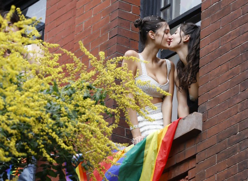 Spectators kiss from a window while watching parade-goers move down the parade route at the 2023 NYC Pride March on June 25, 2023, in New York City. On December 15, 1973, the American Psychiatric Association reversed its longstanding position and declared that being gay isn't a mental illness. File Photo by Corey Sipkin/UPI