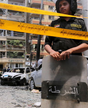 A policeman secures the site of a car bomb attack on the convoy of Egyptian public prosecutor Hisham Barakat near his house at Heliopolis district in Cairo, June 29, 2015. REUTERS/Mohamed Abd El Ghany