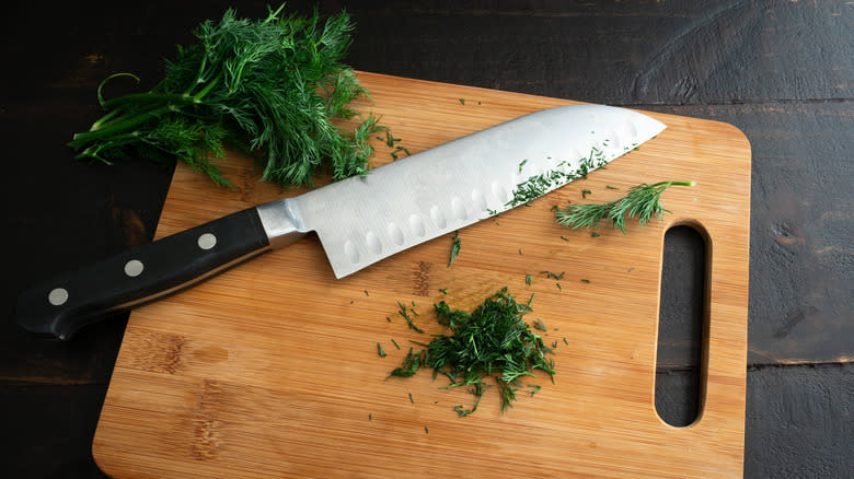 Santoku knife chopping herbs on cutting board