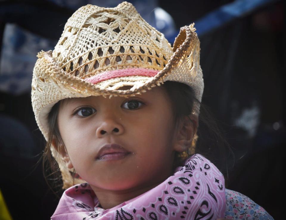 A young girl looks on during the Calgary Stampede parade in Calgary, Friday, July 8, 2016. THE CANADIAN PRESS/Jeff McIntosh