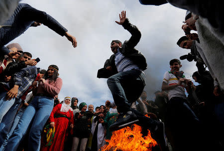 A man jumps over a bonfire during a gathering to celebrate Newroz, which marks the arrival of spring and the new year, in Istanbul, Turkey March 21, 2018. REUTERS/Murad Sezer TPX IMAGES OF THE DAY