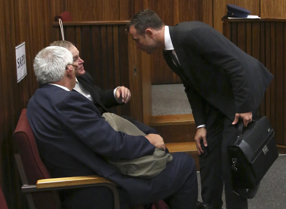 Oscar Pistorius, right, talks talks with his lawyer Barry Roux, 2nd left, at the end the court session for his trial at the high court in Pretoria, South Africa, Monday, March 3, 2014. Pistorius is charged with murder for the shooting death of his girlfriend, Reeva Steenkamp, on Valentines Day in 2013. (AP Photo/Themba Hadebe, Pool)