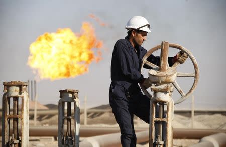 A worker adjusts the valve of an oil pipe at West Qurna oilfield in Iraq's southern province of Basra in this November 28, 2010 file photo.REUTERS/Atef Hassan/Files